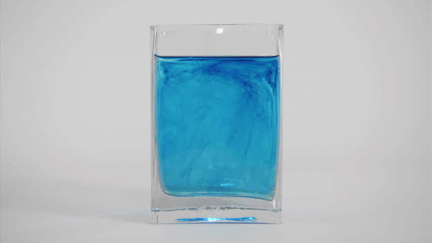 Blue dye diffuses through a glass of water.