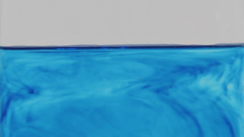 Blue dye diffuses through a glass of water.