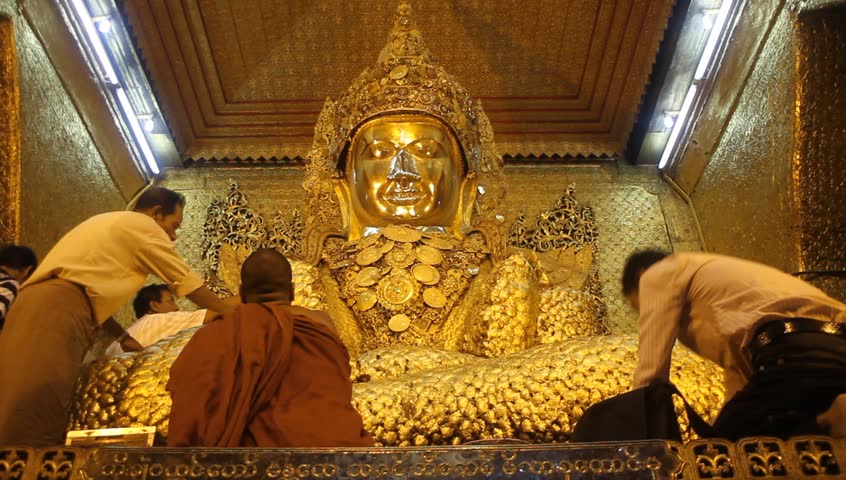 MANDALAY, MYANMAR - AUGUST 20: Monk and people pray near golden Buddha in Mahamuni Paya, August 20, 2011, 