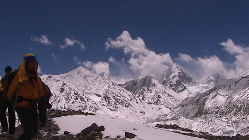 MOUNT EVEREST, TIBET - CIRCA 2005: Climbers walk towards Mt. Everest base camp with Mt. Pumori and the mountains of Nepal in the background, circa 2005 in Tibet.