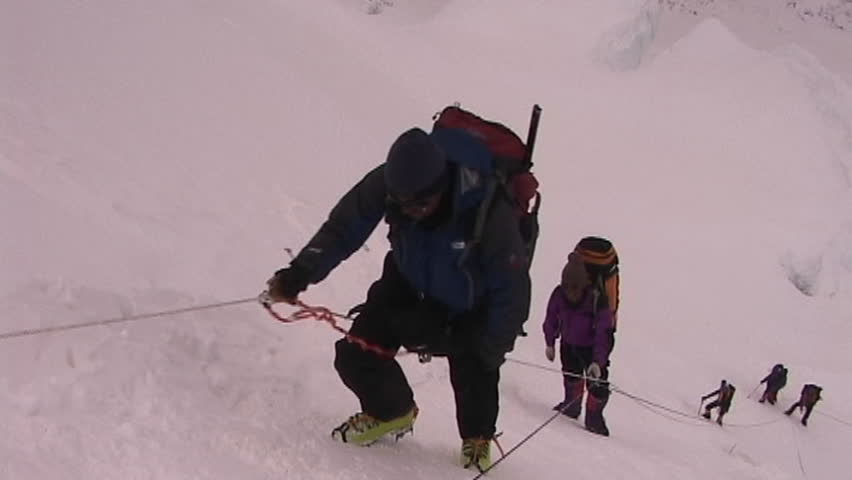 Exhausted climber pauses as he ascends an icy and steep slope circa 2005 in Tibet.