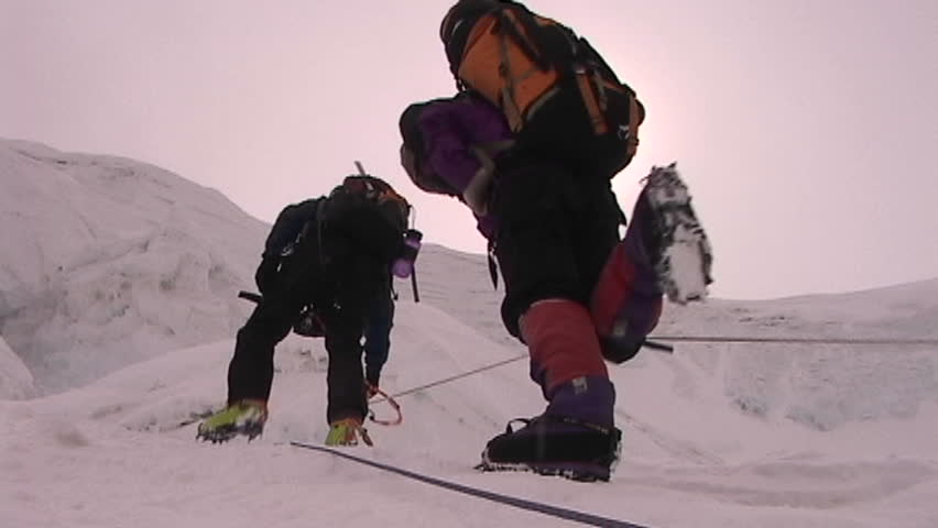 The sun beats down on climbers as they ascend icy slope