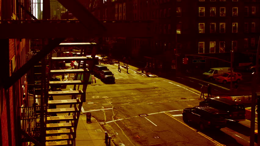 timelapse of a manhattan street, shot from the high line park with a fire escape in the foreground