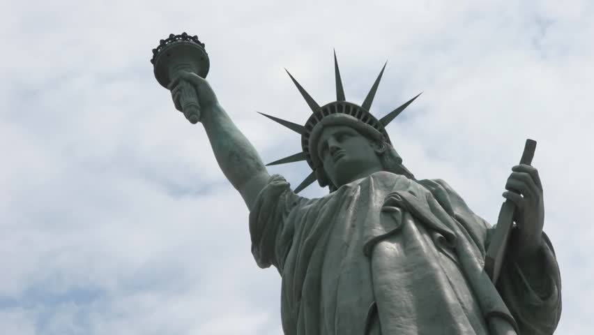 Statue of Liberty stands in front of time-lapse clouds circa 2006 in New York.