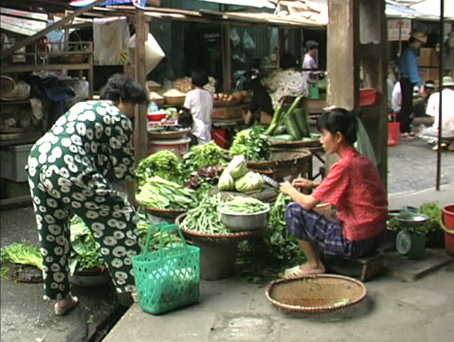 HANOI - CIRCA APRIL 1998: A  market vendor offers vegetables to an  customer circa April 1998 in Hanoi. 