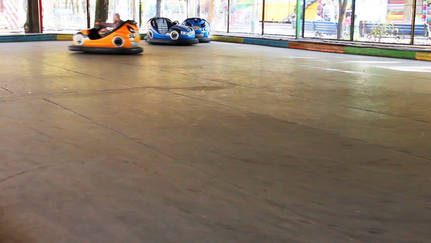 teen girl rides circle and then to camera by car with electric drive in amusement park