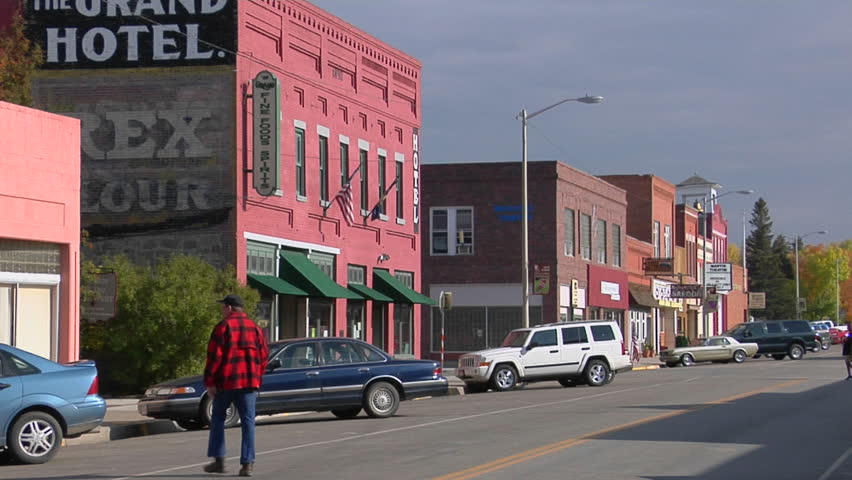 People walk along a street in a quaint Western town.