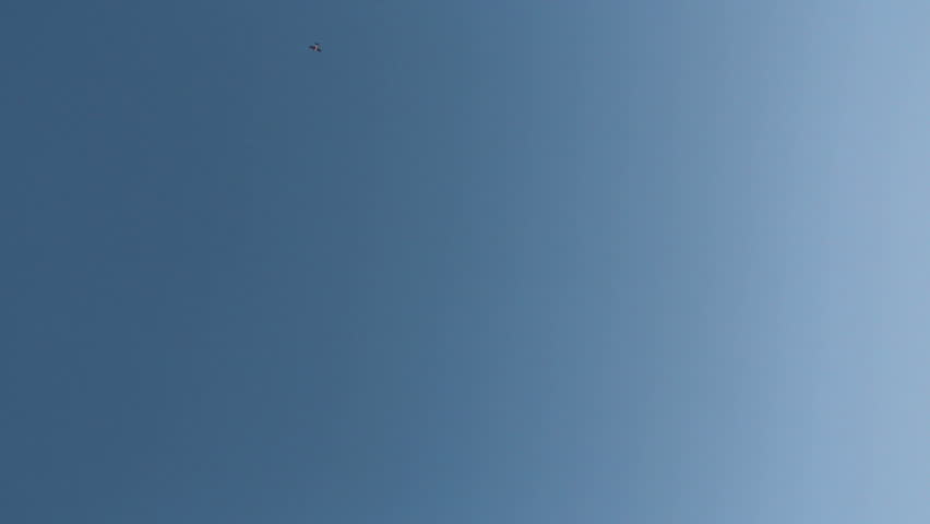 HD footage of a plane flying far above, then a twin engine jet plane passing overhead horizontally.