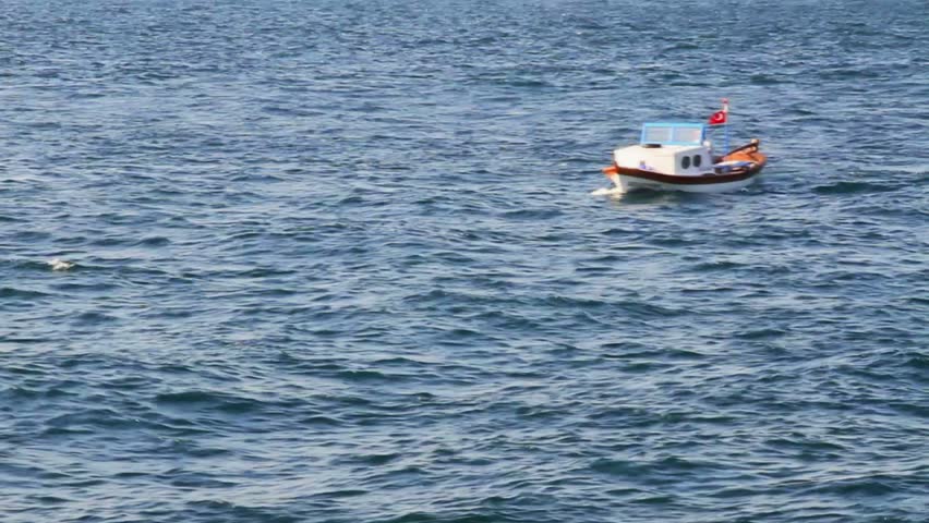 Wooden fisher boat passes through troubled Bosporus waters 