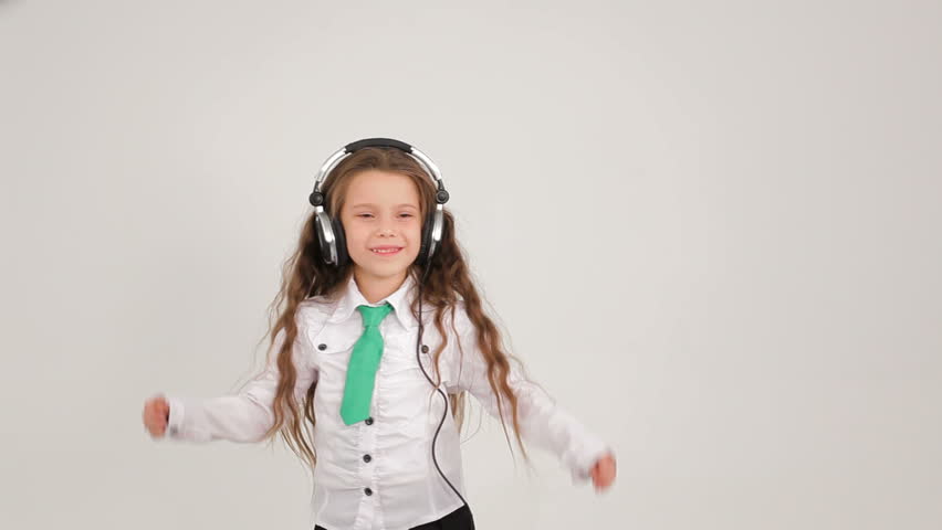 Little girl music. The little girl with long hair dancing with headphones on a white background.