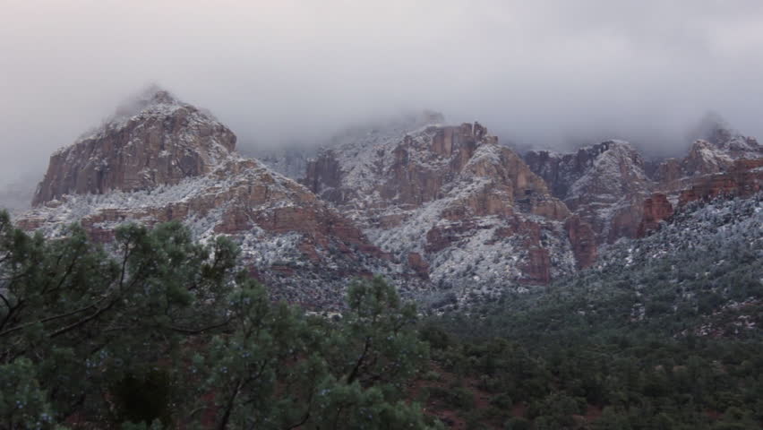 Clouds move slowly over the mountains of Sedona, Arizona after a light dusting of snow in the morning.