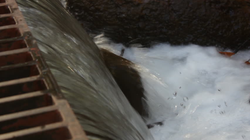 The waters of Oak Creek in Sedona rush quickly from a storm grate as from a recent rain storm.