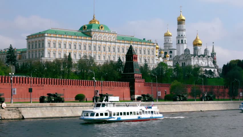 Antiaircraft motorcade ride by quay of Moscow Kremlin, ships sail down the river, red brick walls and Ivan Great Bell Tower. Victory Day 1945 year. Russia.