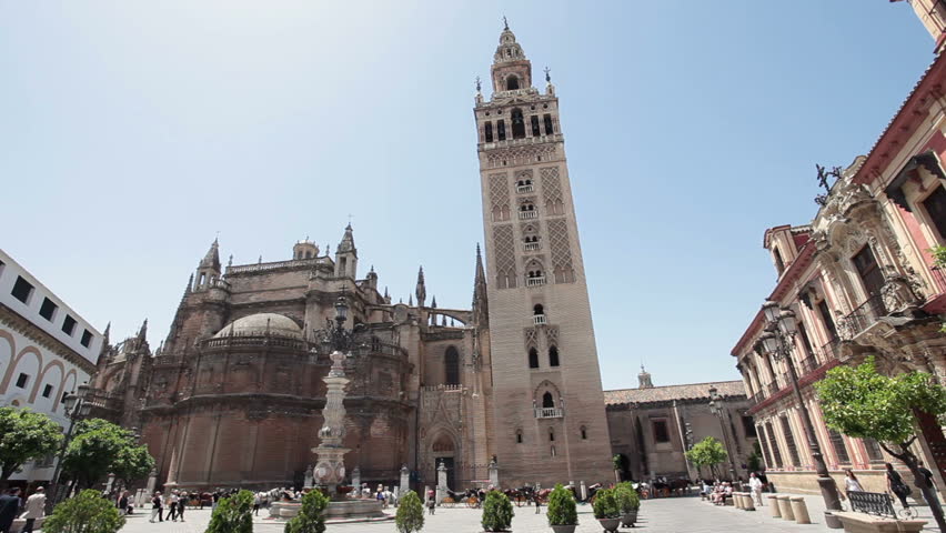Spectators walk around historic Seville Basilica Cathedral in Seville Spain. Tourism money important to struggling economy. Destination for international tourists.