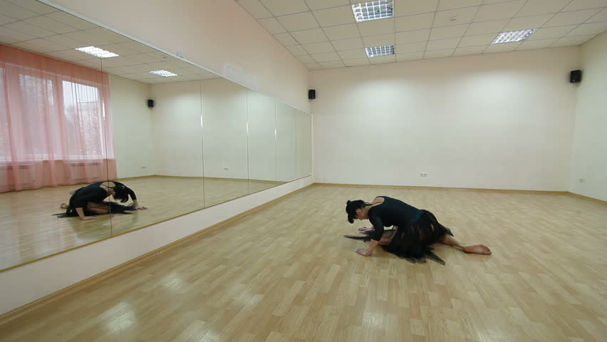 Dancer practicing modern dance in front of the mirror