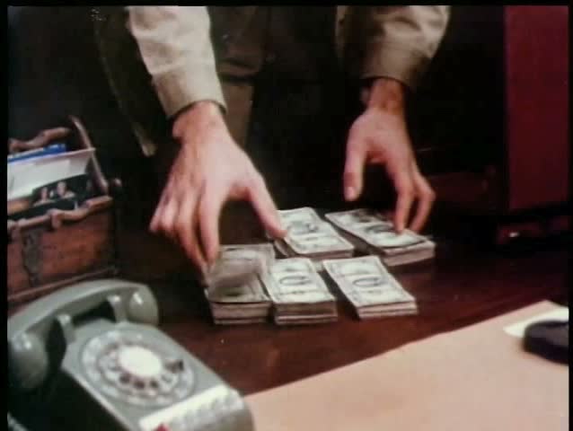 Man stashing stacks of money in briefcase