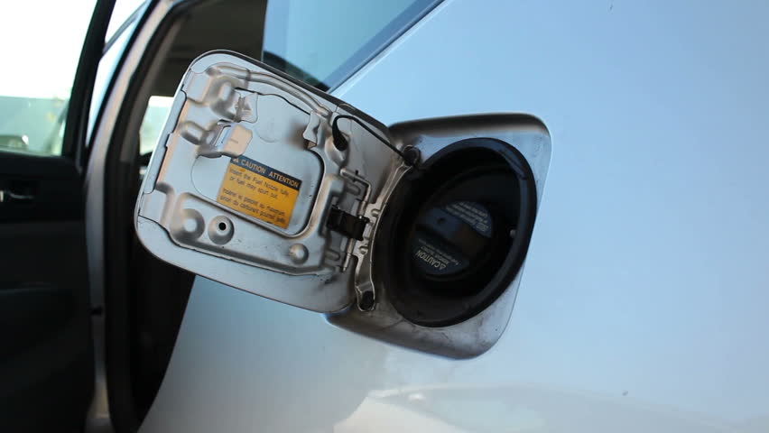 HD clip of a gas pump being inserted into a car's gas port.