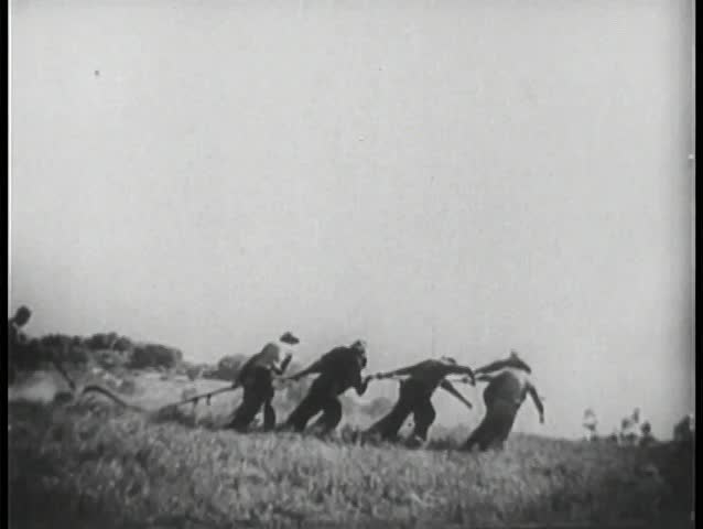 Wide shot of men plowing field