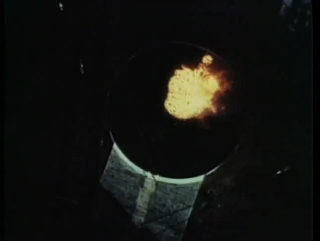 Acrobat high diving into fire inside a water tank at carnival