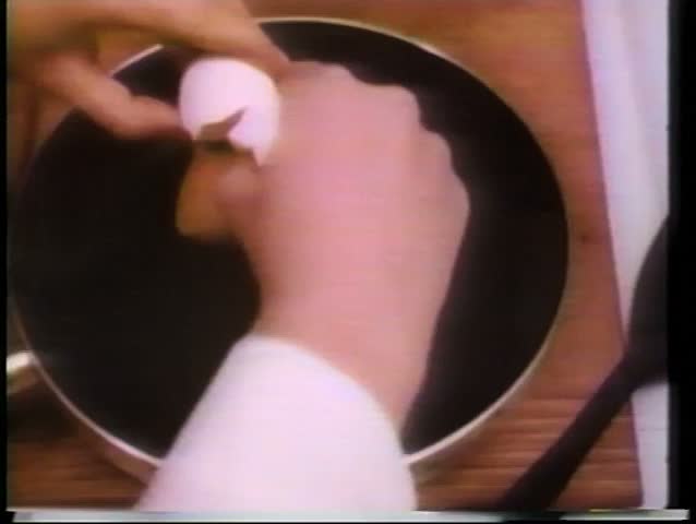 Close-up of hands cooking breakfast in frying pan