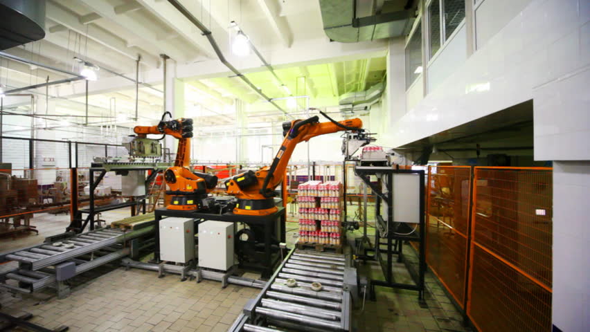 hydraulic crane automatically takes from conveyor and places packages of plastic bottles with yogurt at creamery