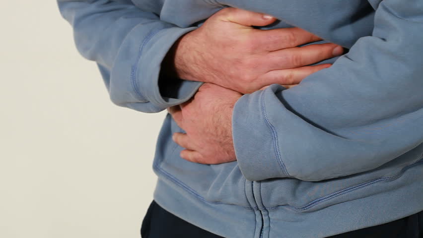 Man holding his hands over his aching stomach
