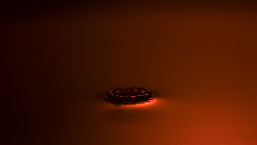 Slow-motion drop hitting water shooting with high speed camera, phantom gold.
