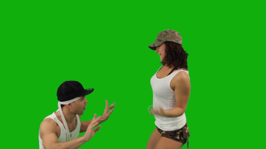 A girl and a guy dressed in military-style clothes dancing hip-hop battle. 