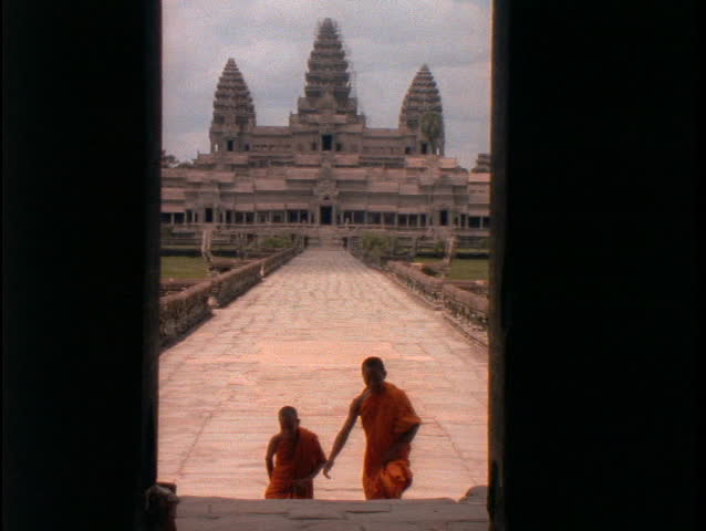 Buddhist monks walk up the stairs of Angkor Wat.