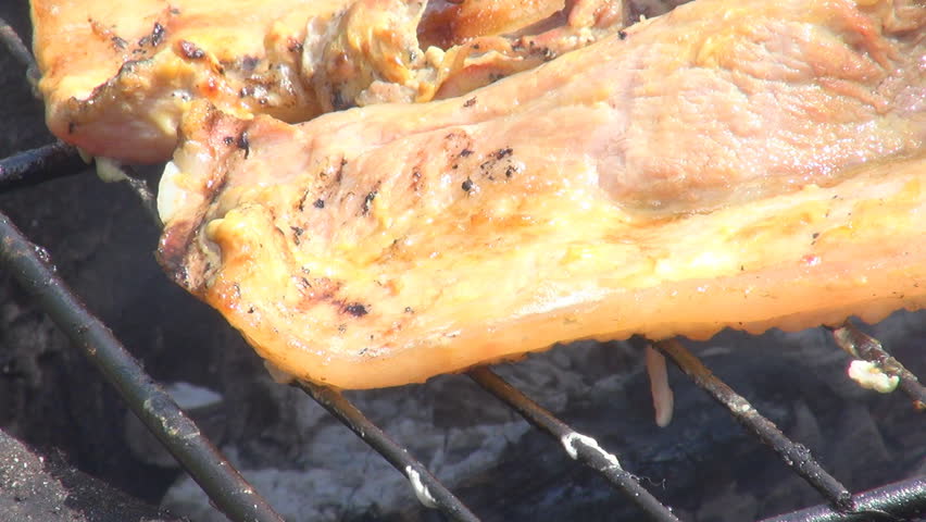 Grilling pork meat, ham, bacon in sunlight