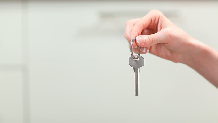 Giving and taking metal key. Video illustrates idea of renting apartment or buying house