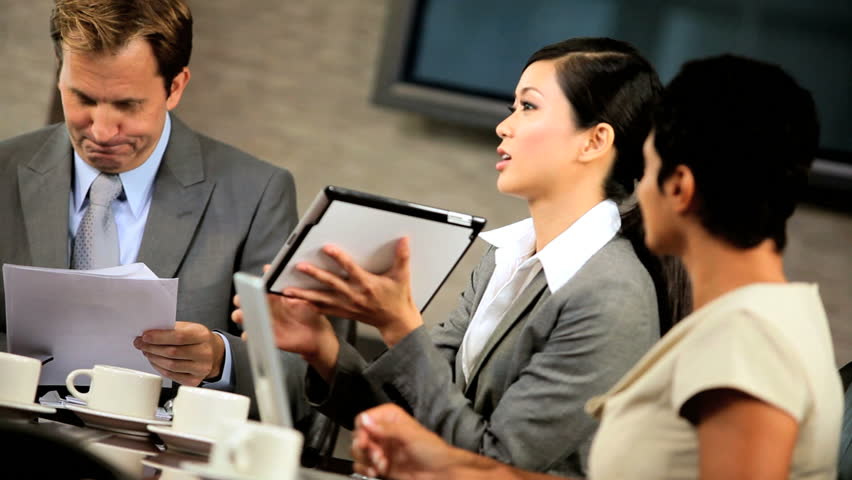 Male caucasian management executive in a boardroom meeting with his multi ethnic business team