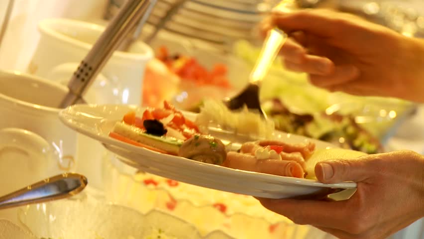 Restaurant guests select food from a buffet
