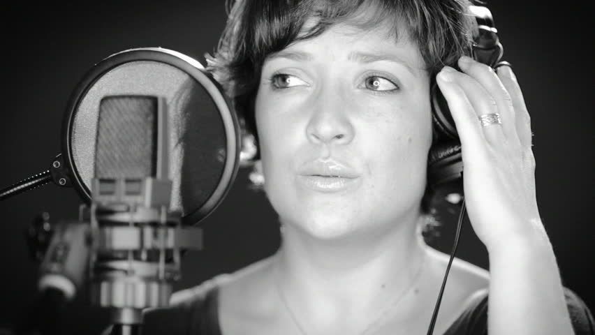 A young singer recording a song in a recording studio
