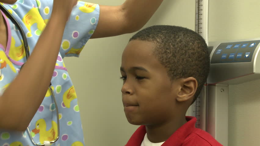 Young boy waits to have his height measured