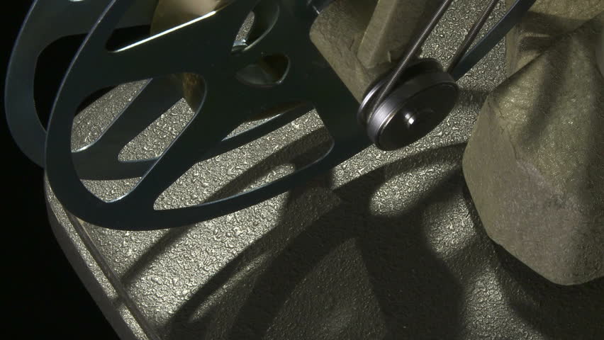 Close up of rotating 16mm film take up reel on projector
