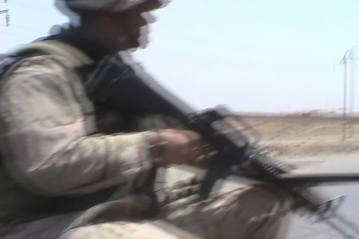 BAGHDAD, IRAQ - CIRCA 5/19/03: "Red Crescent" ambulance passes column of U.S. Humvees on highway, siren blaring.