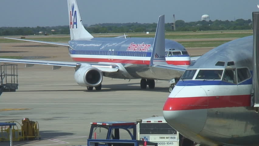 Busy airport vehicles drive past passenger jet starting to taxi for departure
