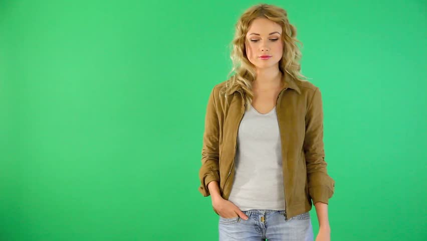 Young woman on green background talking to camera