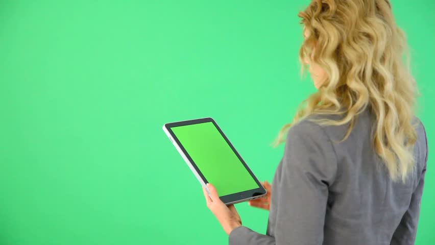 Backview of businesswoman on green background with digital tablet