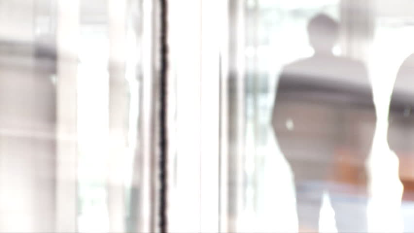 Businessman reflection in glass rotating door