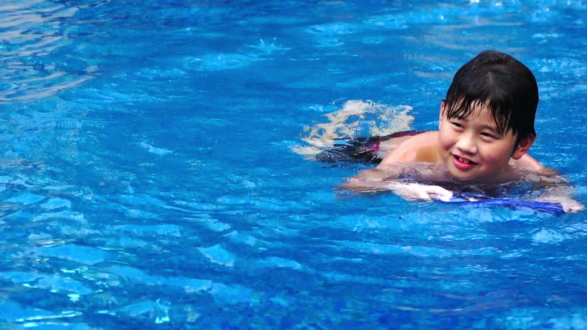 Asian chubby boy swimming towards camera.