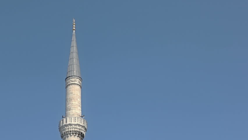 Pan shot from minaret to the tourists walking and watching famous Blue mosque situated in  Sultanahmet park on September 28, 2011 in Istanbul, Turkey.