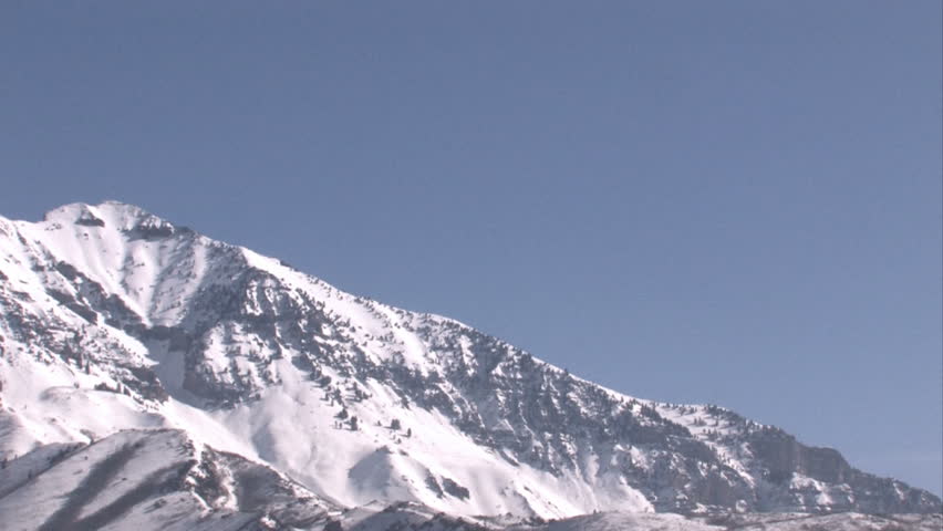 Timpanogos Mountain,Wasatch Range, Rocky Mountains, central Utah. Summit height of 11,749 feet. Pan left. Popular mountain climbing destination. Pan right of bright blue skies and snow covered peaks.