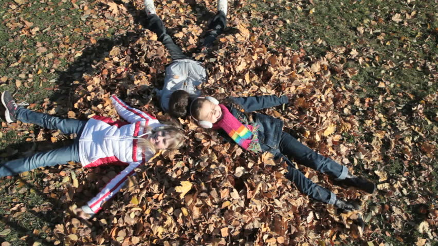 Overview of children playing with autumn leaves and making a mess