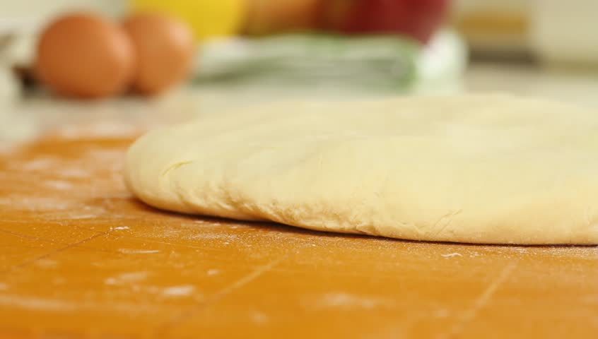 Female hands preparing pastry on silicone rolling board