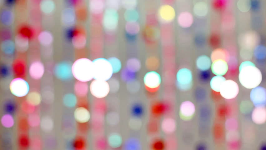 blind cords from of colorful beads flickering on gray background, in defocus