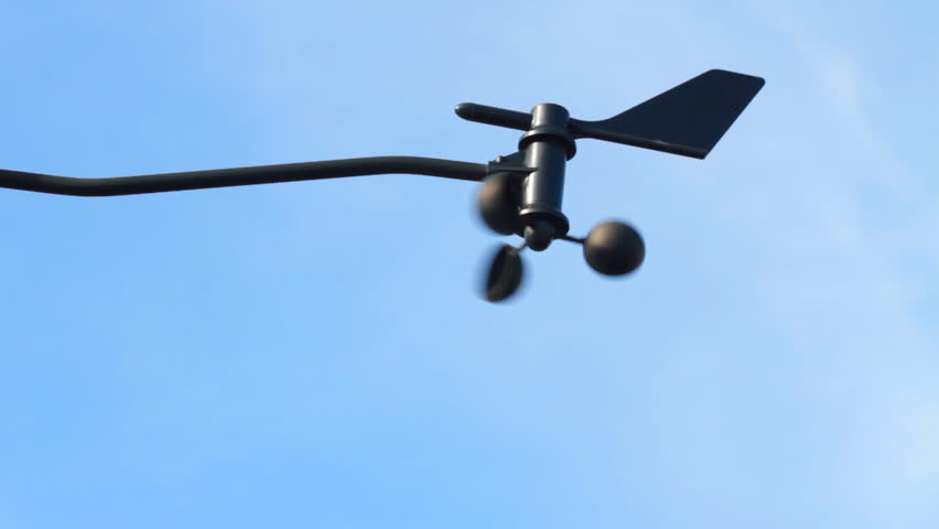 An anemometer blows in the wind against a perfect blue sky