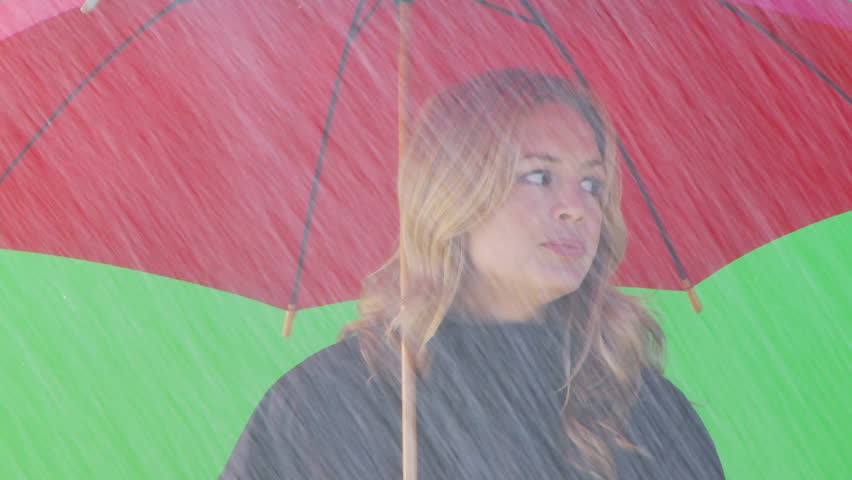 Close up of female standing under umbrella waving to taxi