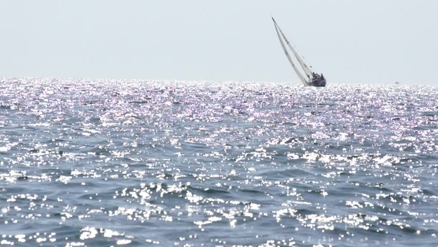 The yacht sailing on the sea and slowly takes over the horizon